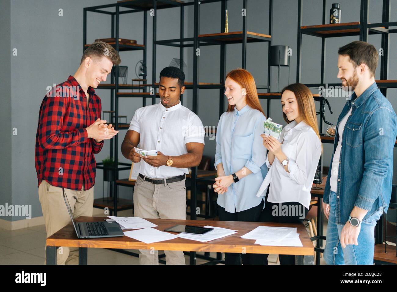 African American man manager giving salary in cash to happy employees.  Concept of money rain Stock Photo - Alamy