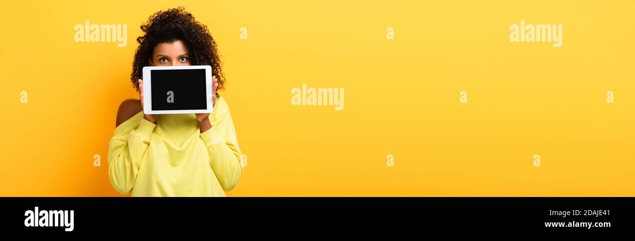 african american woman covering face with digital tablet with blank ...