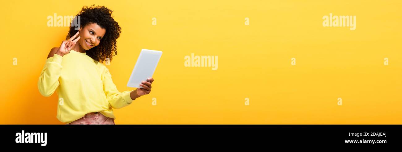 cheerful african american woman holding digital tablet and showing ...