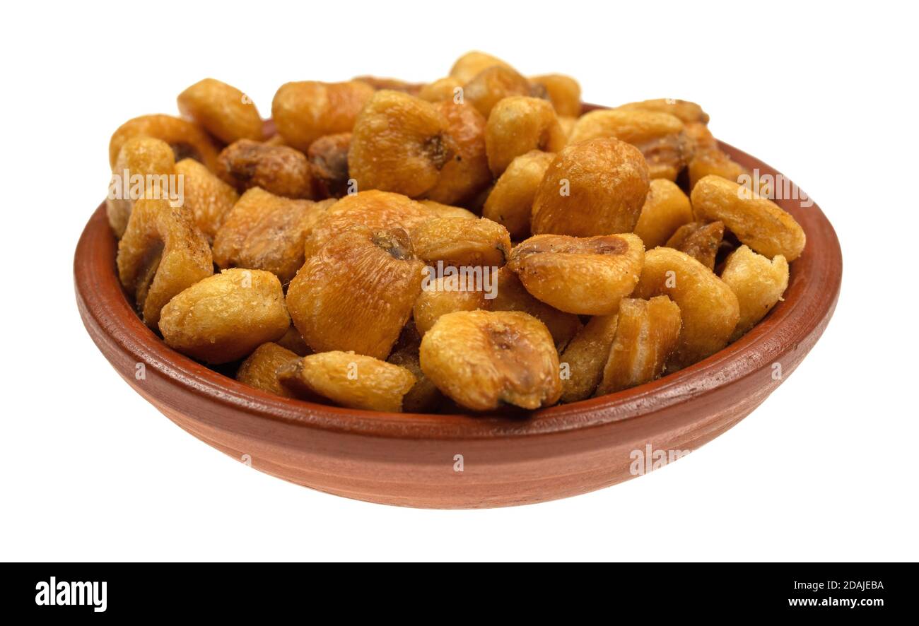 Small clay bowl of organic corn nuts isolated on a white background. Stock Photo