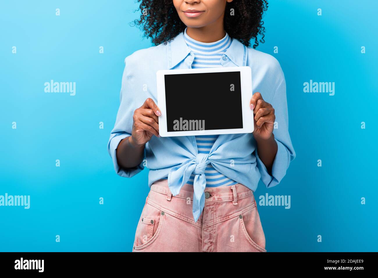 cropped view of curly african american woman holding digital tablet ...