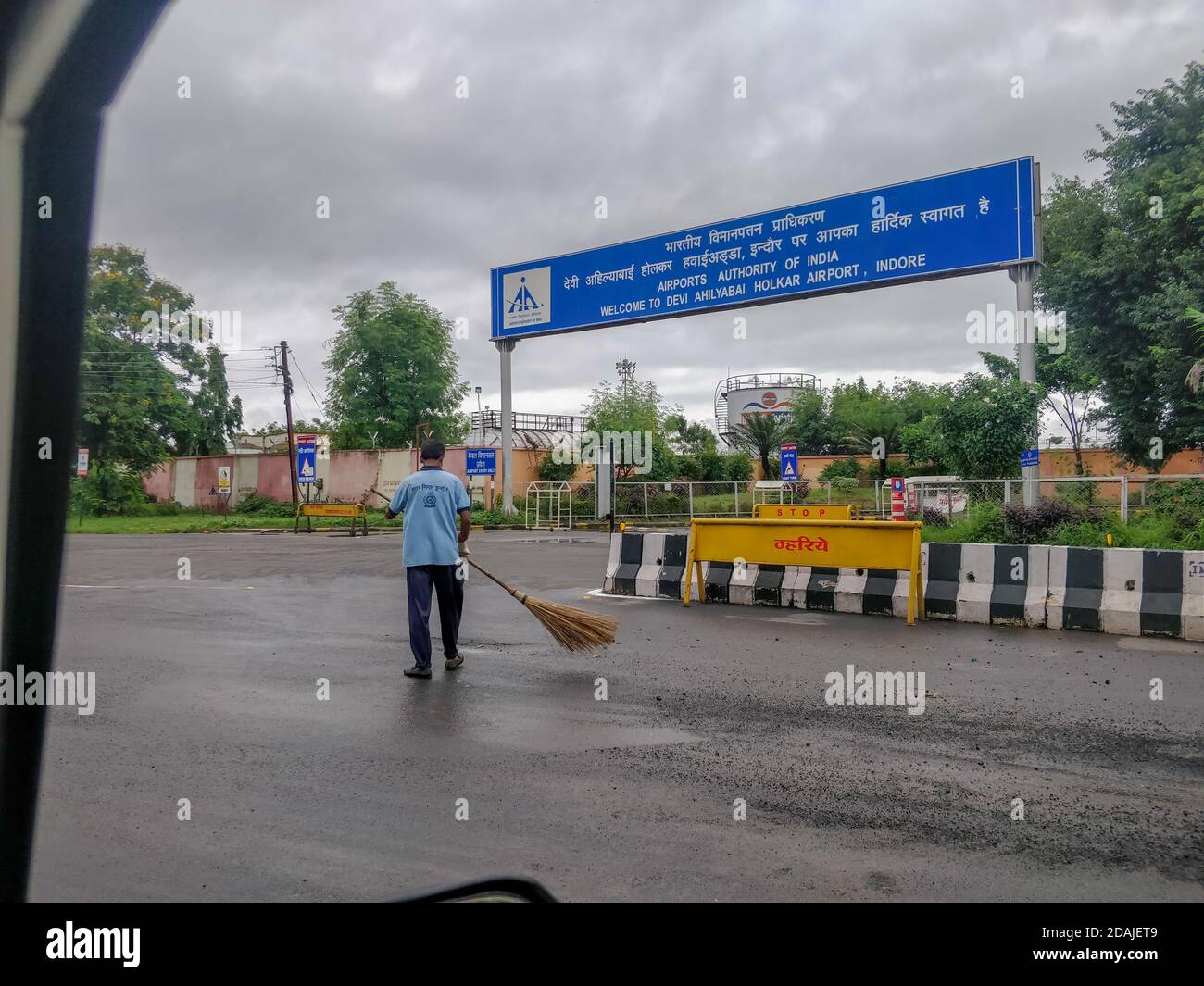 Indore, India - August 22nd 2020: Worker cleaning road outside Indore Airport. Stock Photo