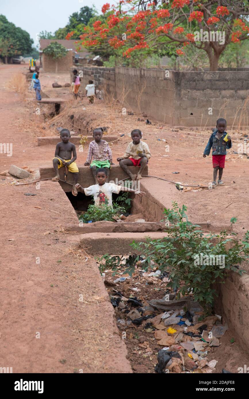 Selingue, Mali, 26th April 2015; Chidren playing around clogged storm drains in the late afternoon. Stock Photo