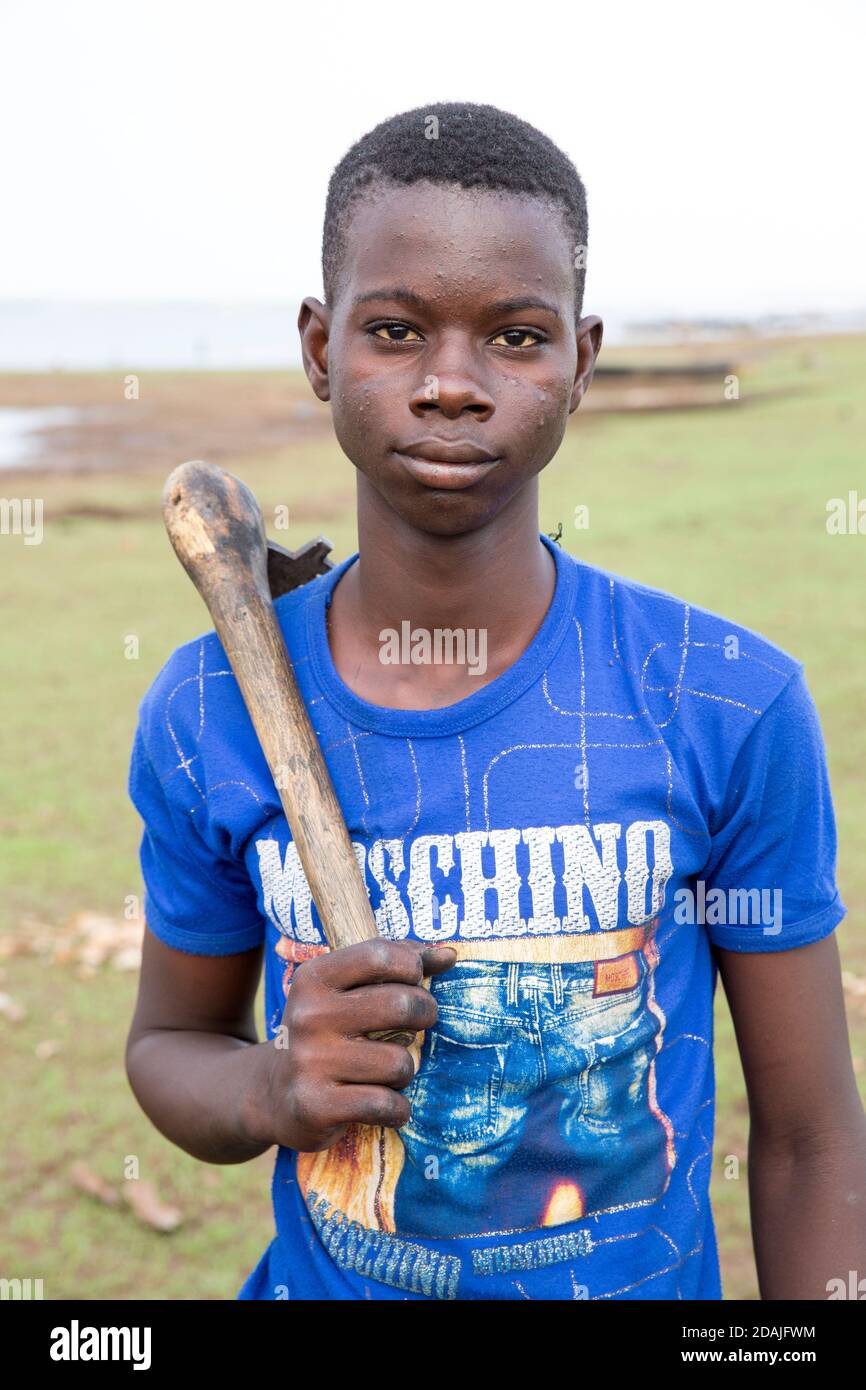 Selingue area, Mali, 27th April 2015; Boat builder and repairer, Ke Karonta, 17 (blue shirt) has never been to school.  His father is a boat builder and he is following in his father's footsteps. Stock Photo