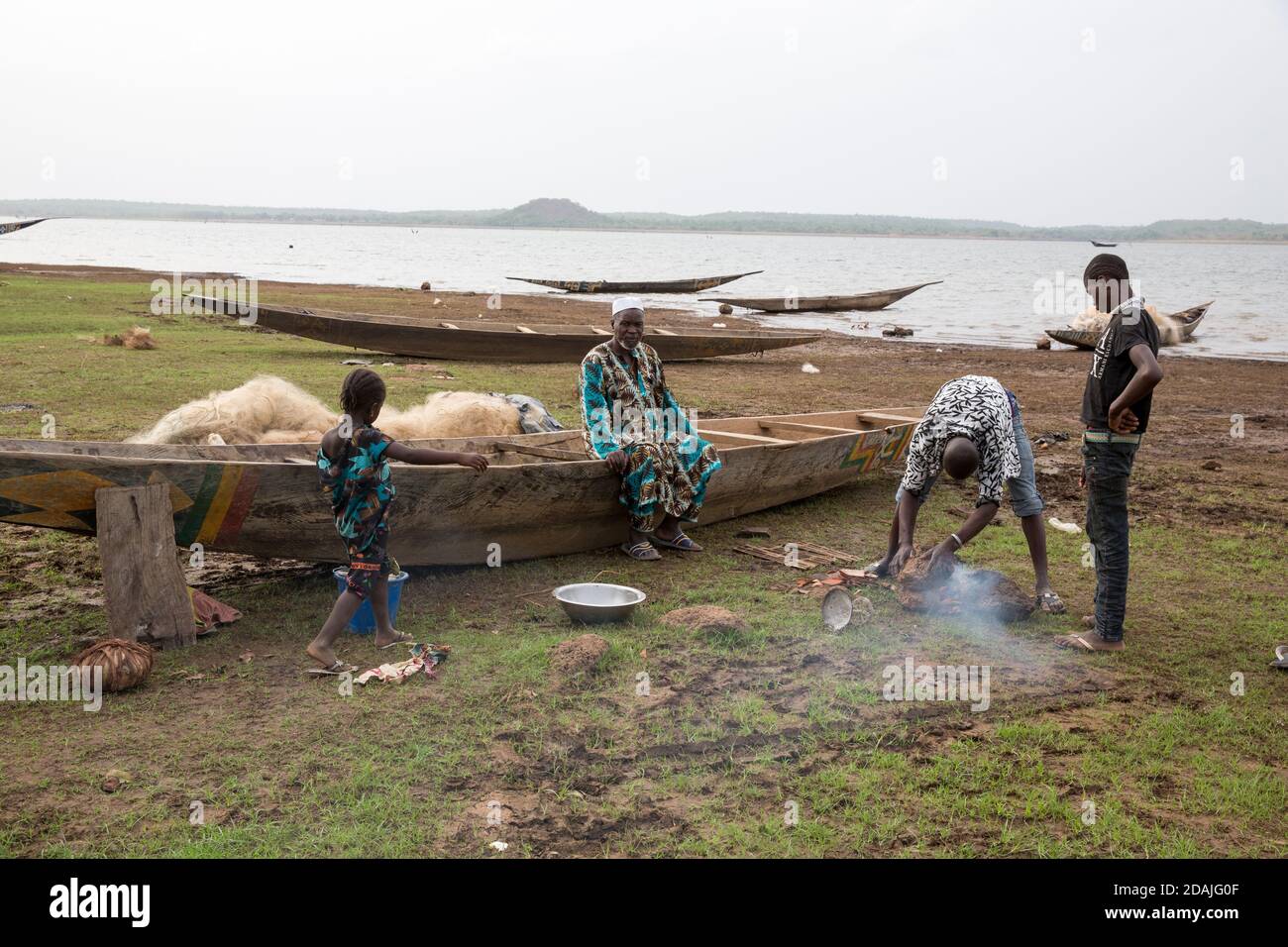 Selingue area, Mali, 27th April 2015; Boubacar Kente, 70, is a fisherman. He wants to restore his old boat by sealing it with natural fat extracted from the nuts of native karité (shea) trees. Boubacar says that before the dam was built the water level was far lower, there were many villages in the river bed and many garden plots. All these were lost when the dam was built and the people relocated. Bozo fishermen from Mopti and Segou now arrive every dry season because of the abundance of fish in the new dam lake, and some like him stay the year round. Stock Photo