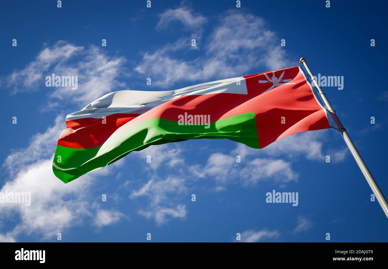 Beautiful national state flag of Oman fluttering at sky background. Low