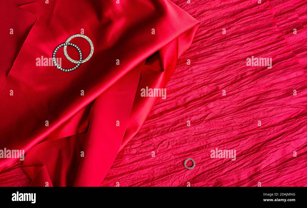 Red background and metal rings. Two textures of fabric. Satin and