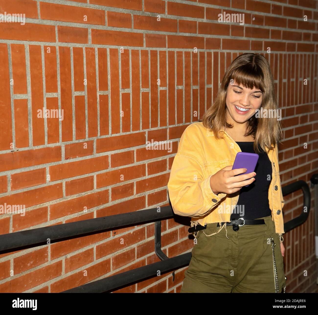 Beautiful young stylish woman walking in the night city streets using ...