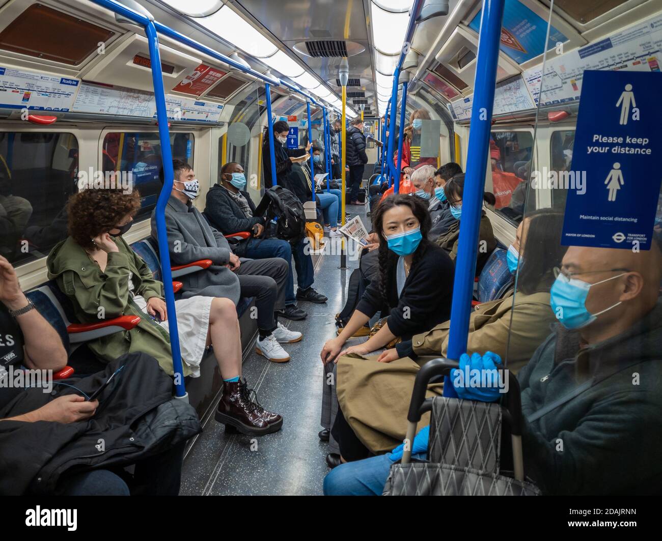 Passengers on the London Underground wearing face mask and social