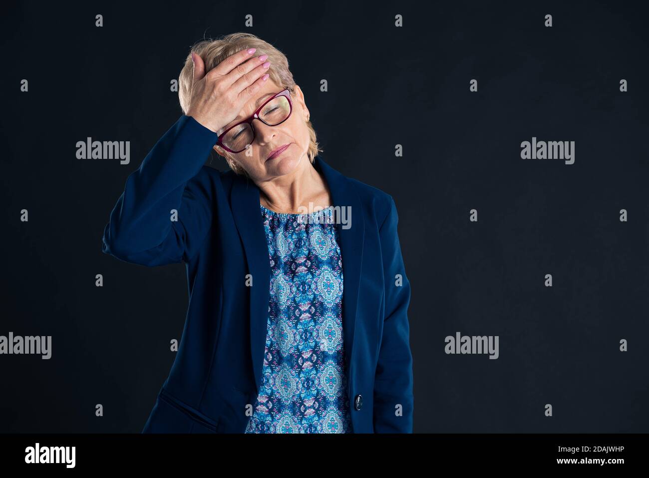 Portrait of an older businesswoman having a headache wearing glasses Stock Photo