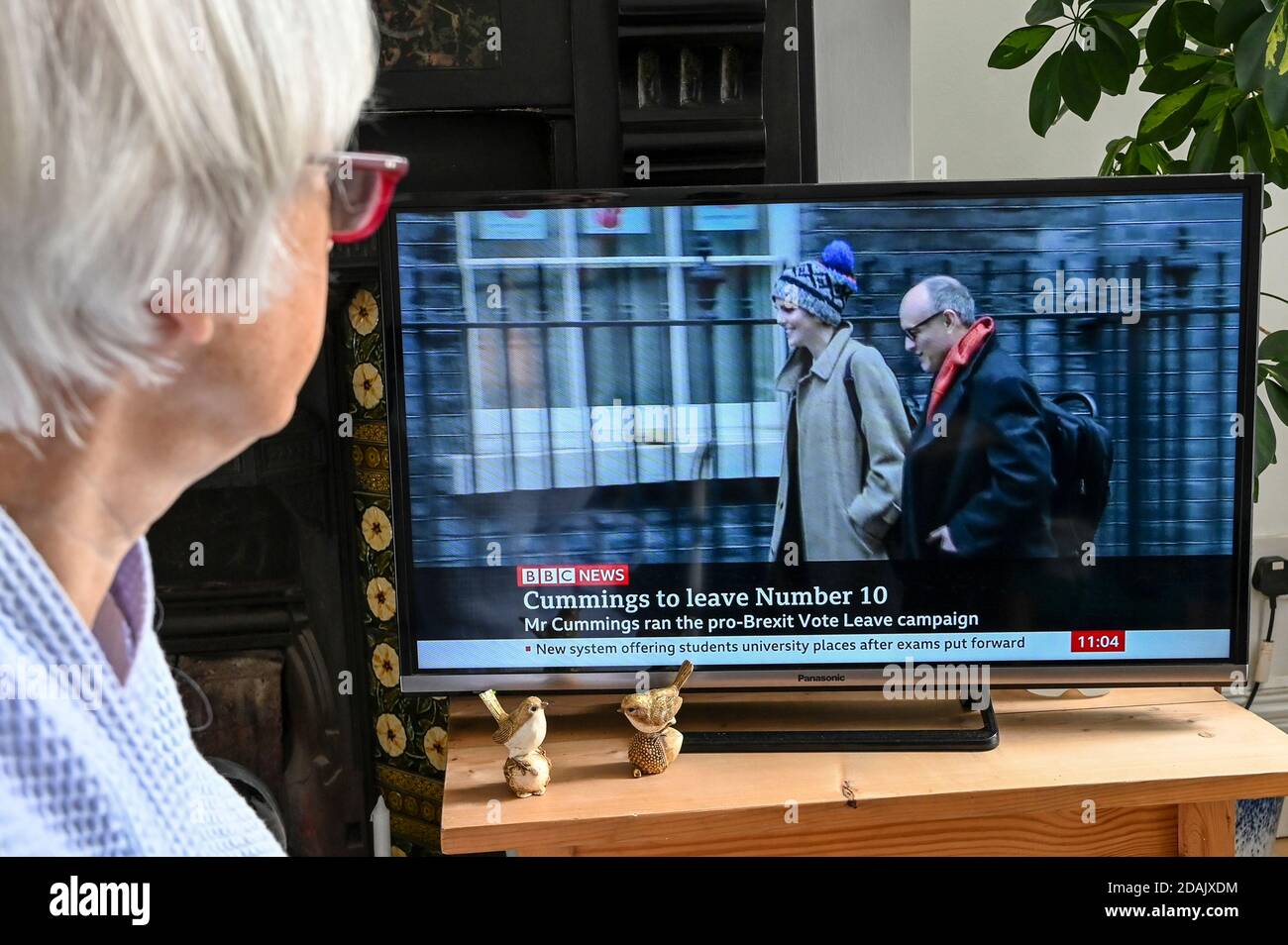 Televised news report of Dominic Cummings resigning as chief advisor to Boris Johnson with caption 'Cummings to leave Number 10', watched by a viewer. Stock Photo