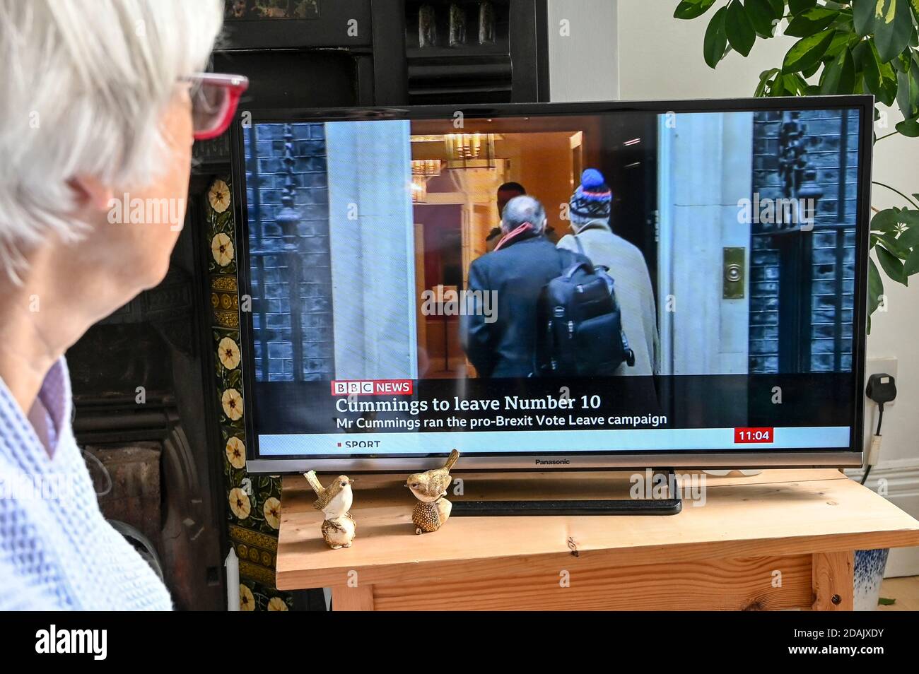 Televised news report of Dominic Cummings resigning as chief advisor to Boris Johnson with caption 'Cummings to leave Number 10', watched by a viewer. Stock Photo