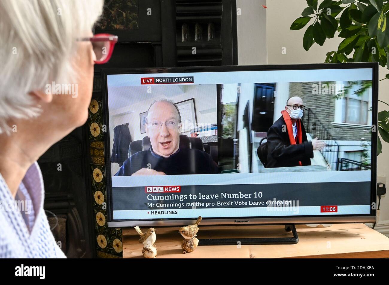 Televised report of Dominic Cummings resigning as advisor to Boris Johnson with comment from Daniel Finkelstein Times Editor, watched by a viewer. Stock Photo