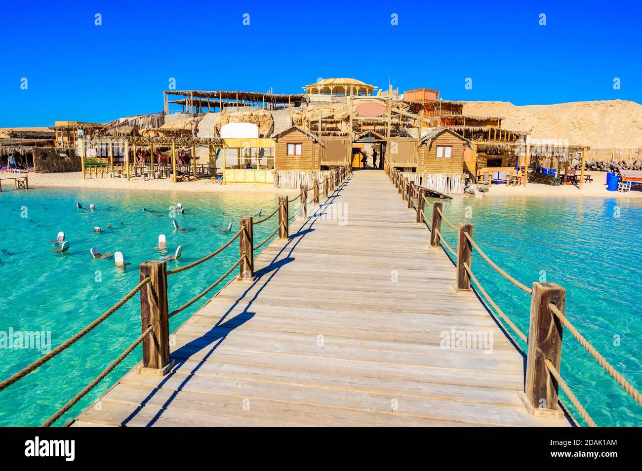 Wooden Pier at Orange Bay Beach with crystal clear azure water and white beach - paradise coastline of Giftun island, Mahmya, Hurghada, Red Sea, Egypt Stock Photo