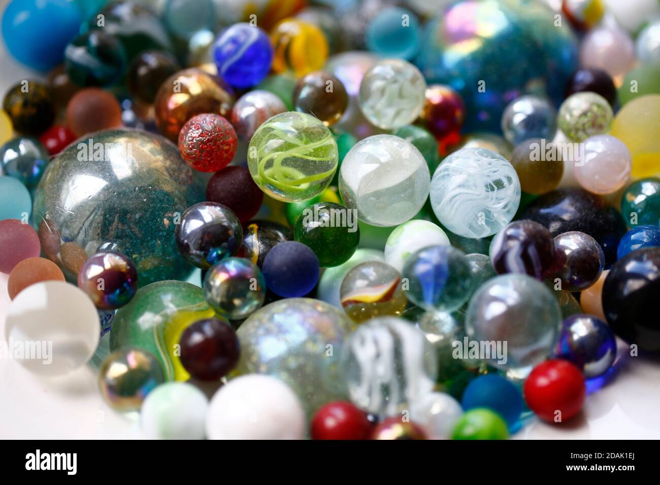 Coloured glass marbles in a bowl, in natural light. Stock Photo