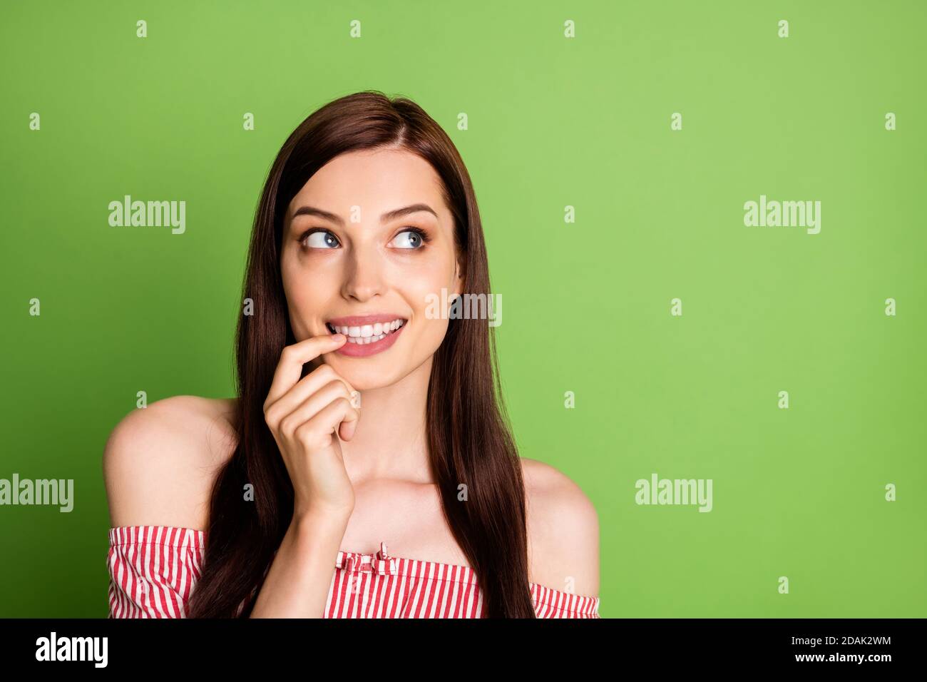 Photo of adorable tricky student girl look finger touch lips break boyfriend computer imagine he find out wear striped white red shirt uncovered Stock Photo