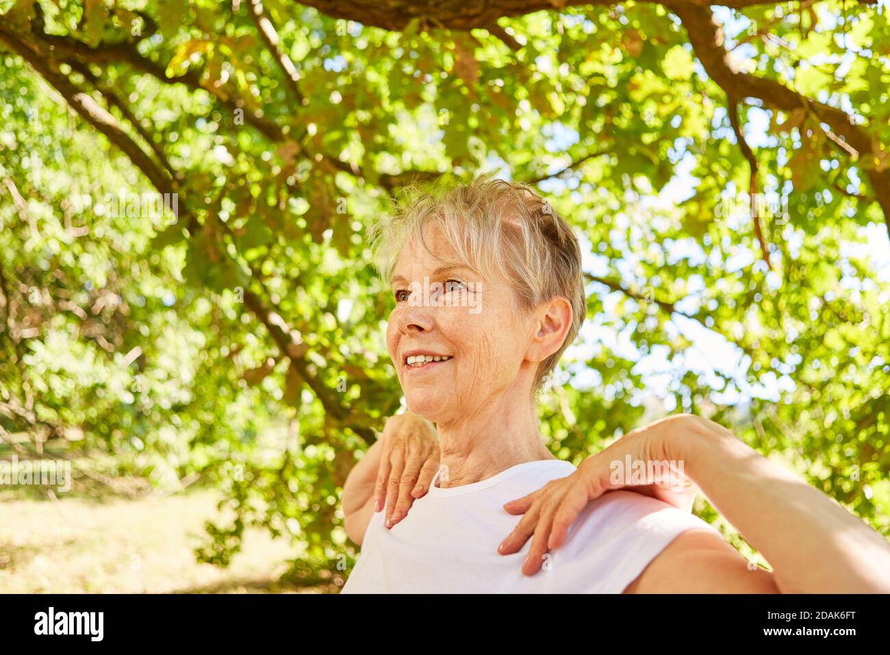 Elderly smiling woman doing a yoga breathing exercise for relaxation and health Stock Photo