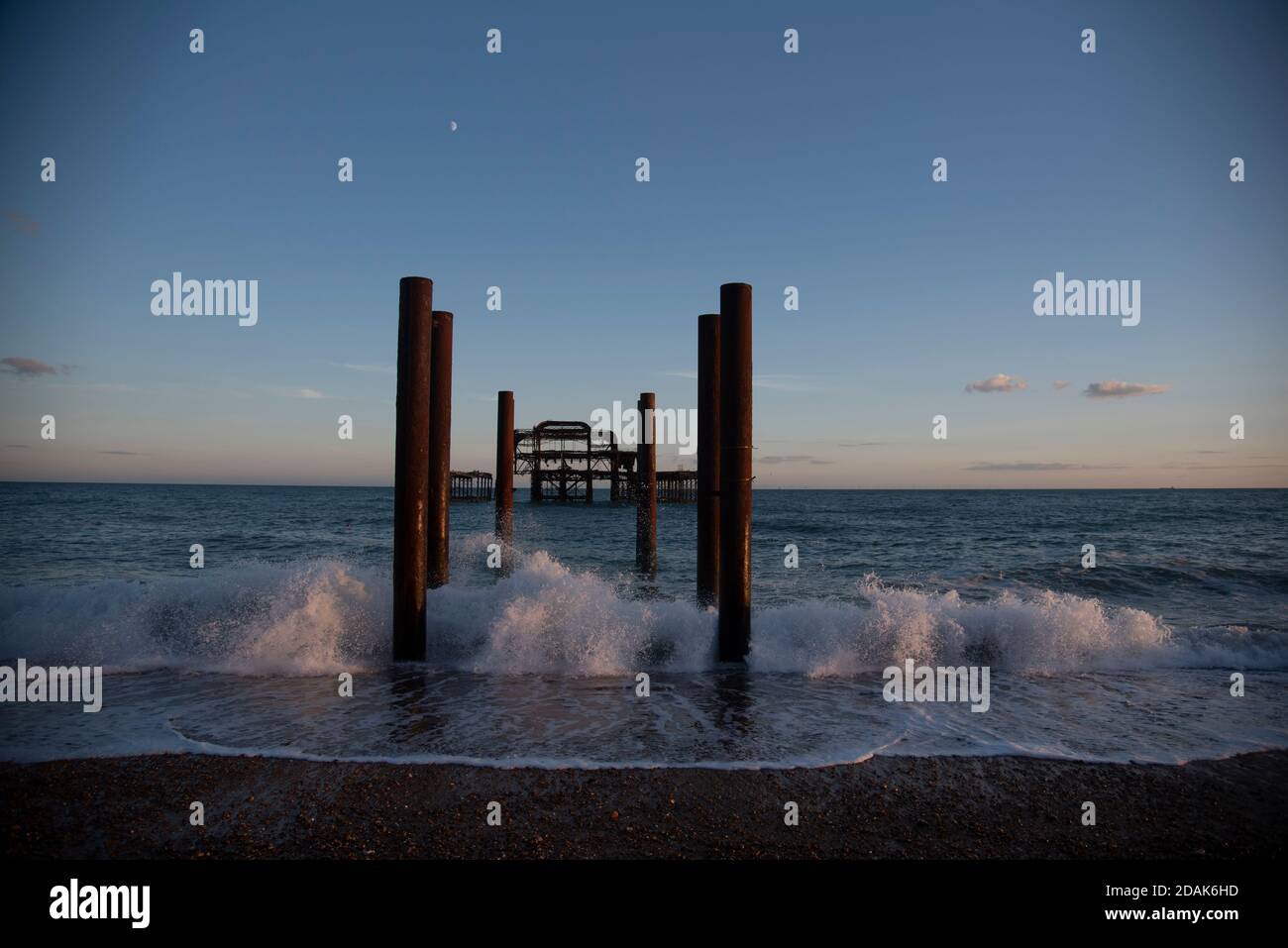 Waves crashing around the remains of Brighton's West Pier on the East Sussex Coast. Taken at sunset during summer. Brighton, UK Stock Photo