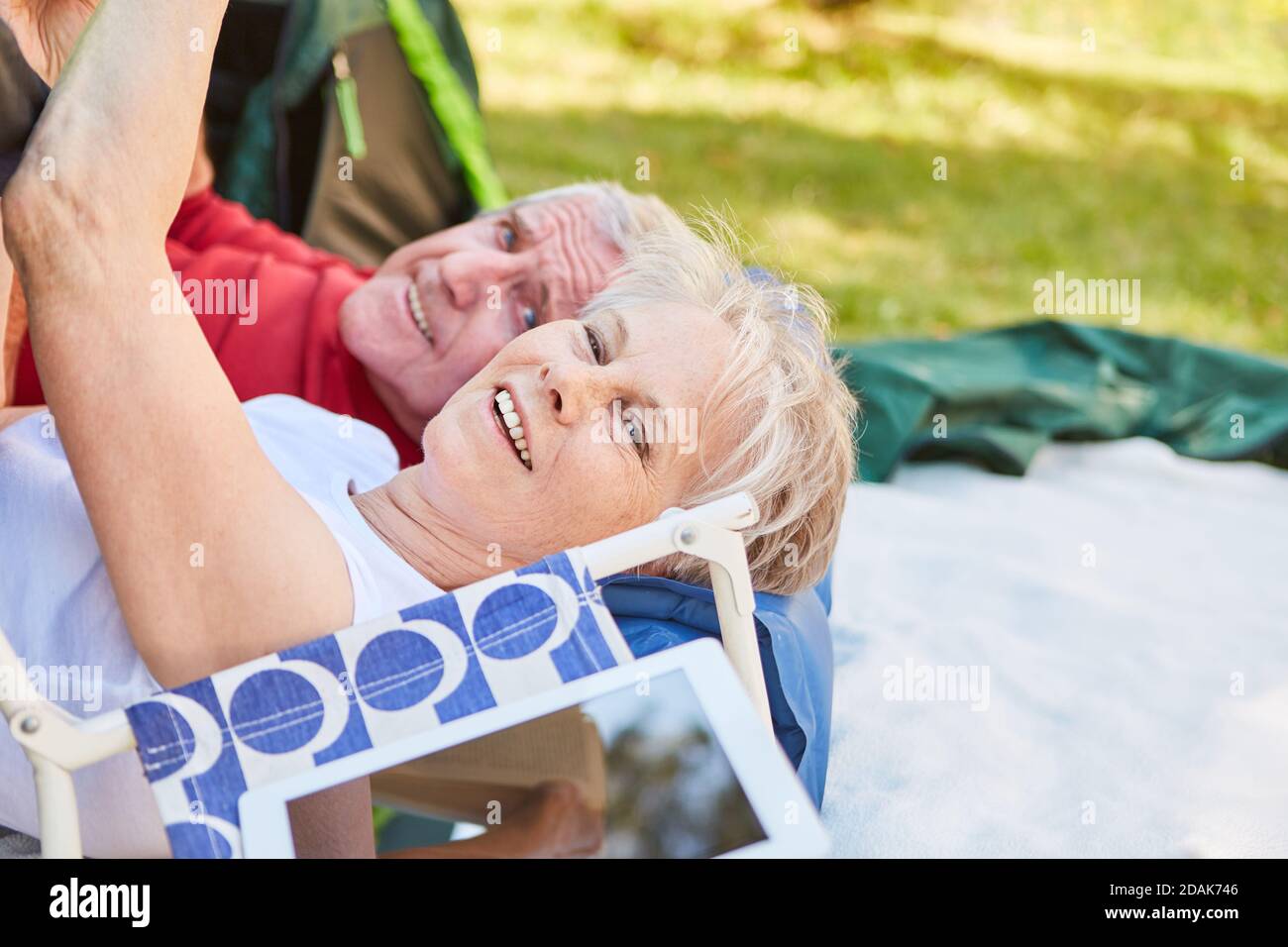 Vital senior couple relaxing together while camping in nature on vacation Stock Photo