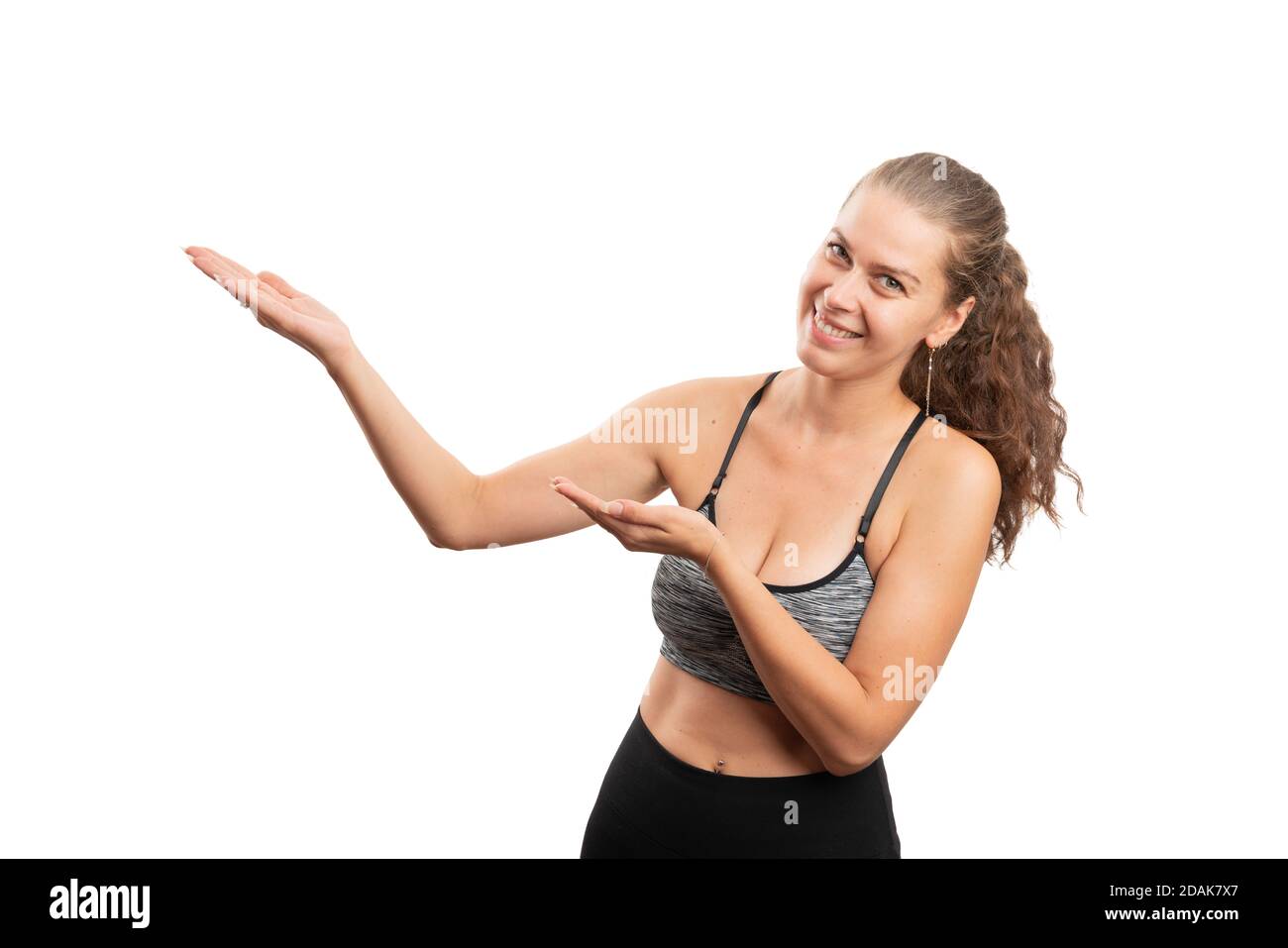 Athletic adult woman model wearing fitness gym sportswear presenting blank copyspace using hands or palms as active healthy lifestyle concept isolated Stock Photo