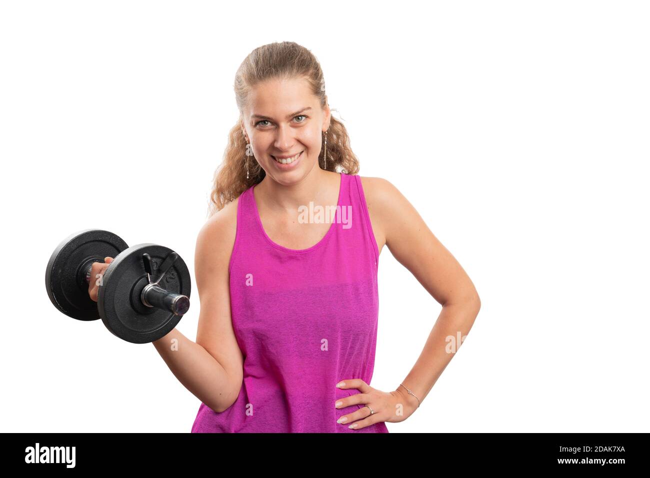 Sporty female model wearing pink sportswear tanktop smiling as working out using weigh dumbbells to tone biceps muscles isolated on white studio backg Stock Photo