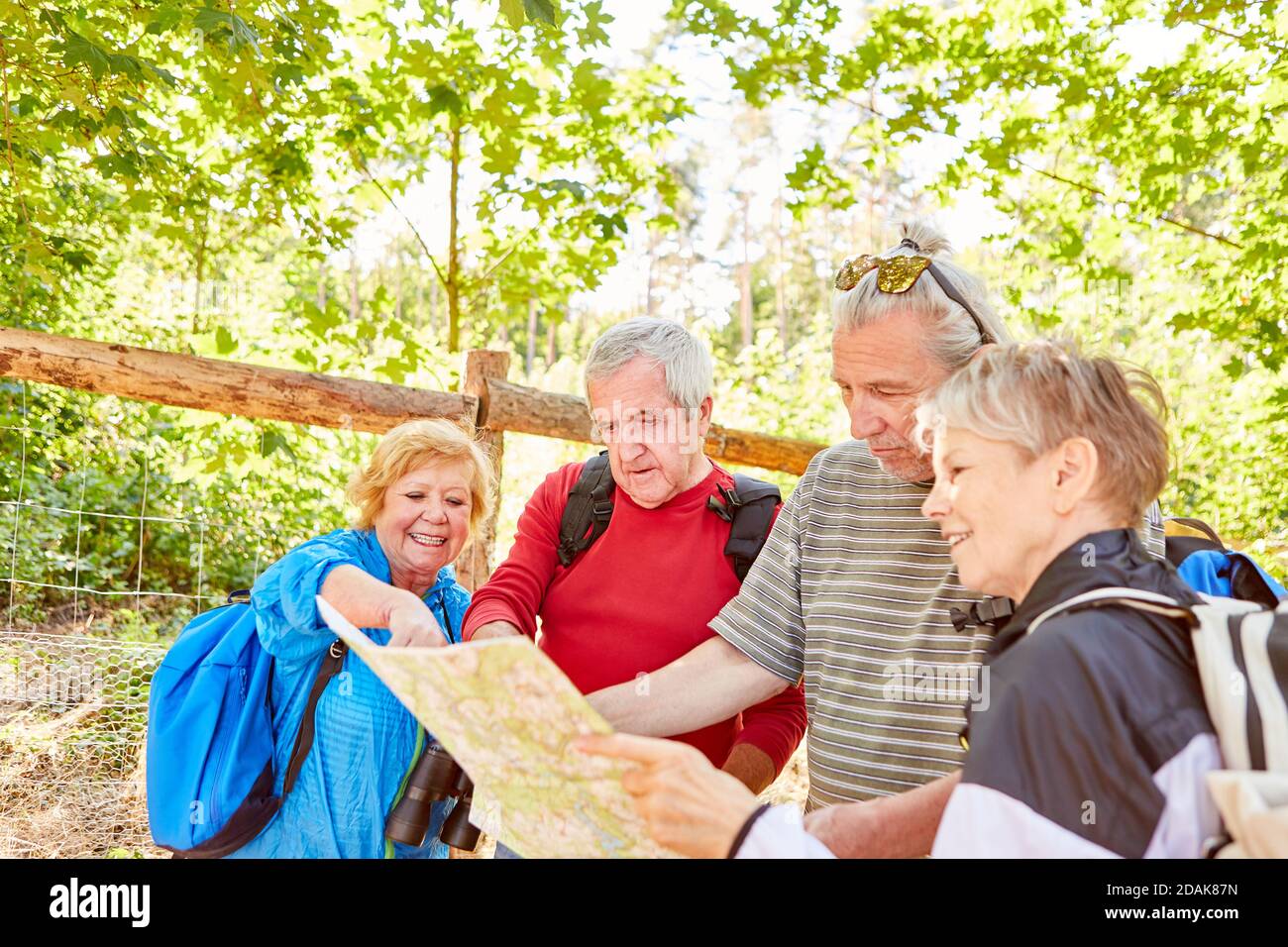 Active senior hiking group hiking or on a trekking tour with a map