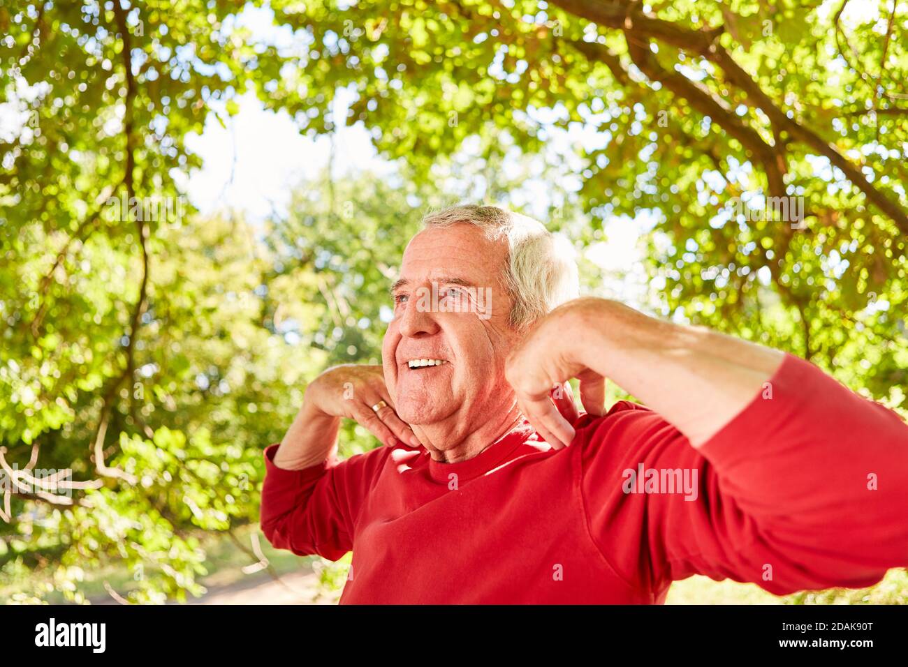 Smiling senior man doing a yoga breathing exercise for health and relaxation Stock Photo