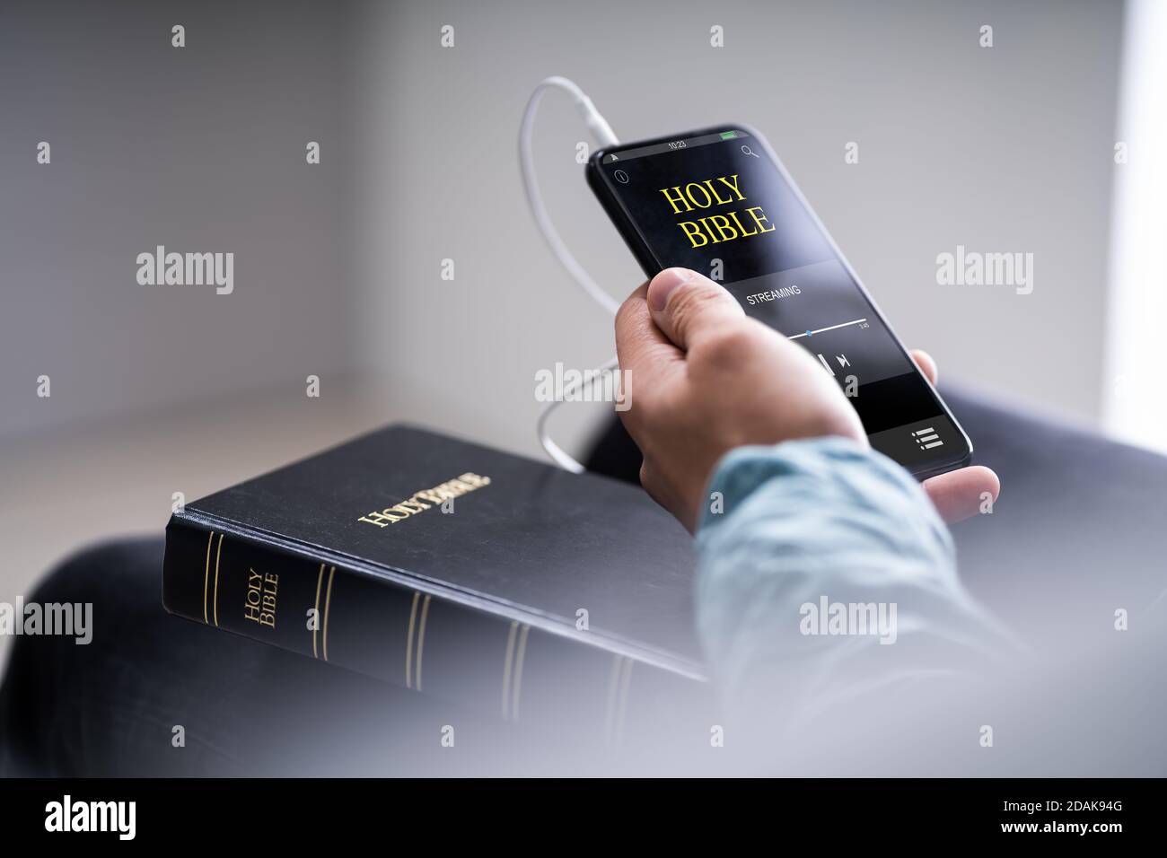 Christian Man Reading Bible Book On Phone And Praying Stock Photo