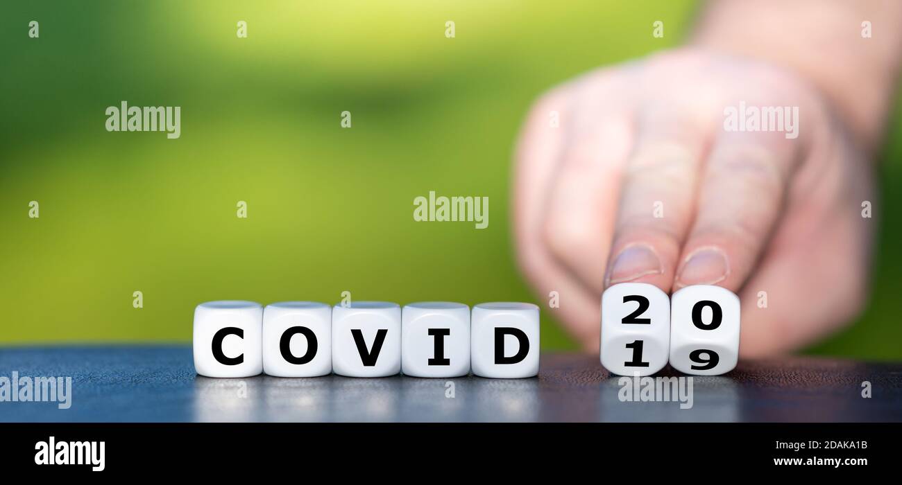 Symbol for the next virus pandemic. Hand turns dice and changes the expression 'covid 19' to 'covid 20'. Stock Photo