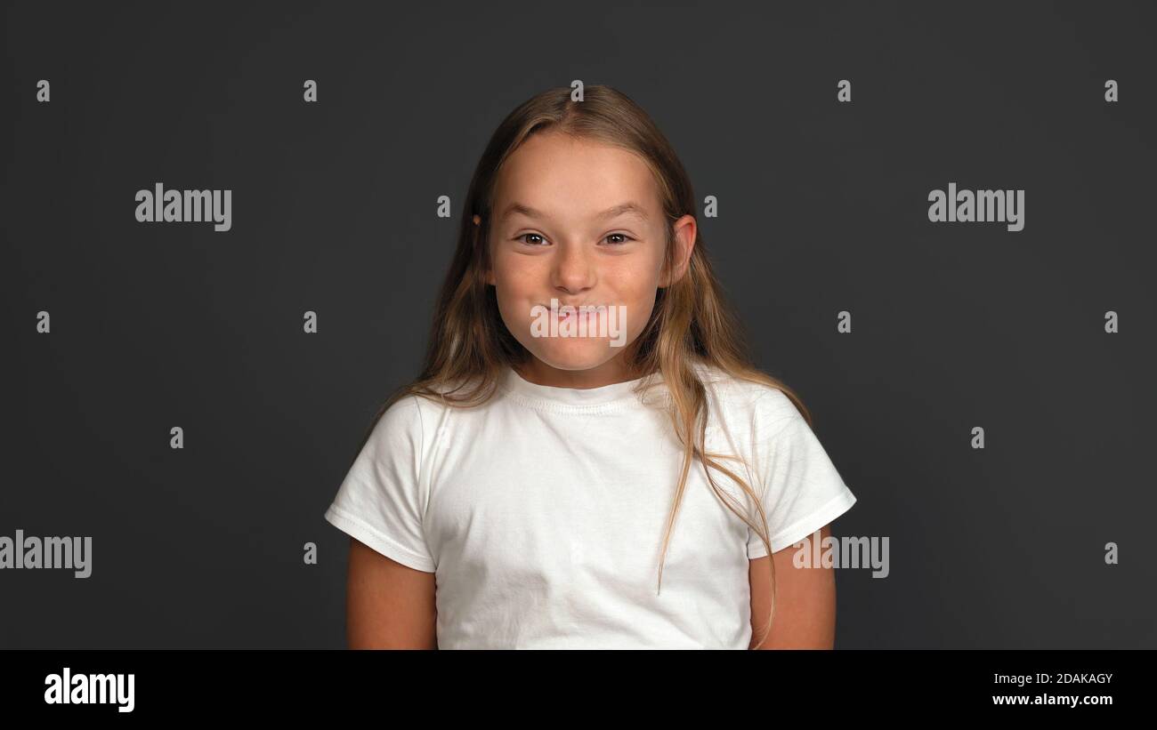 Funny teen girl puffed cheeks laughing. Emotions concept. Close up shot. Isolated on gray background. Copy space Stock Photo