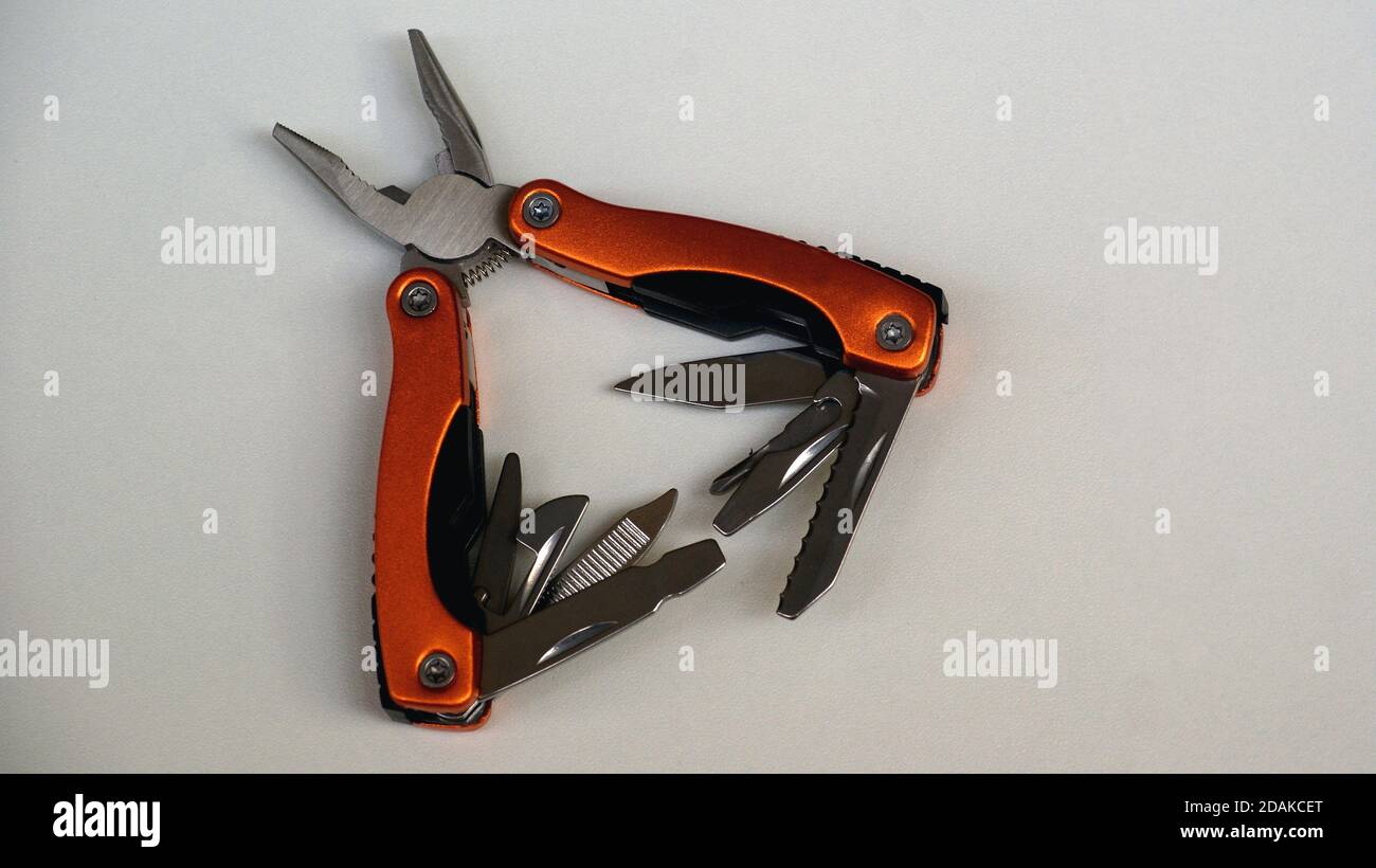 Pliers, multifunctional with functional tools, for use at home, in orange color with white background, copy space, side view, open Stock Photo