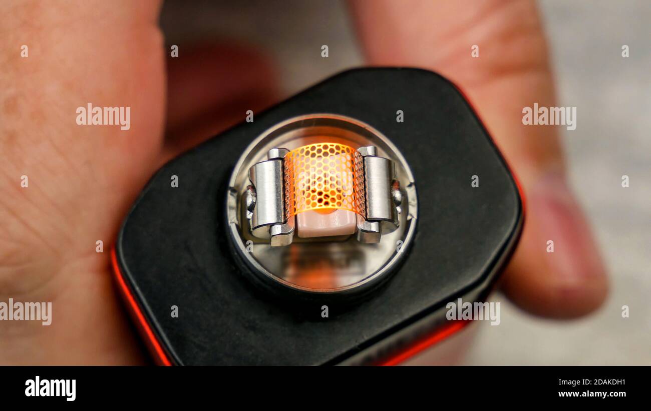 Preparation of mesh coil in the atomizer for vaping - Slightly glowing coil  Stock Photo