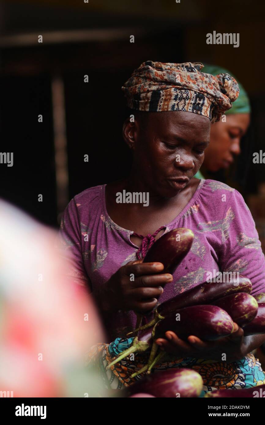 A portrait of a woman selling eggplant. Sierra Leone. Stock Photo