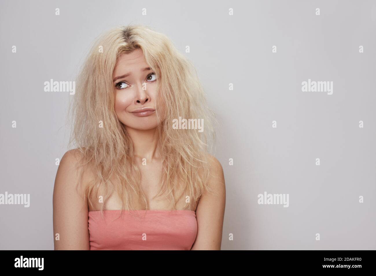 Bad hair day. Beautiful woman with messed up hair. Unhappy grimacing ...