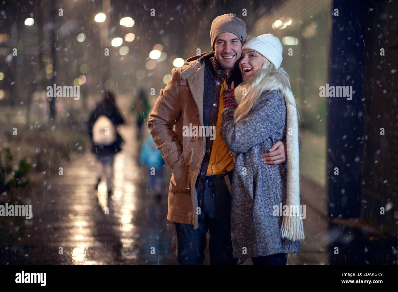 A young couple having good time together on a snowy weather in the city. Love, together, walk, snow, city Stock Photo