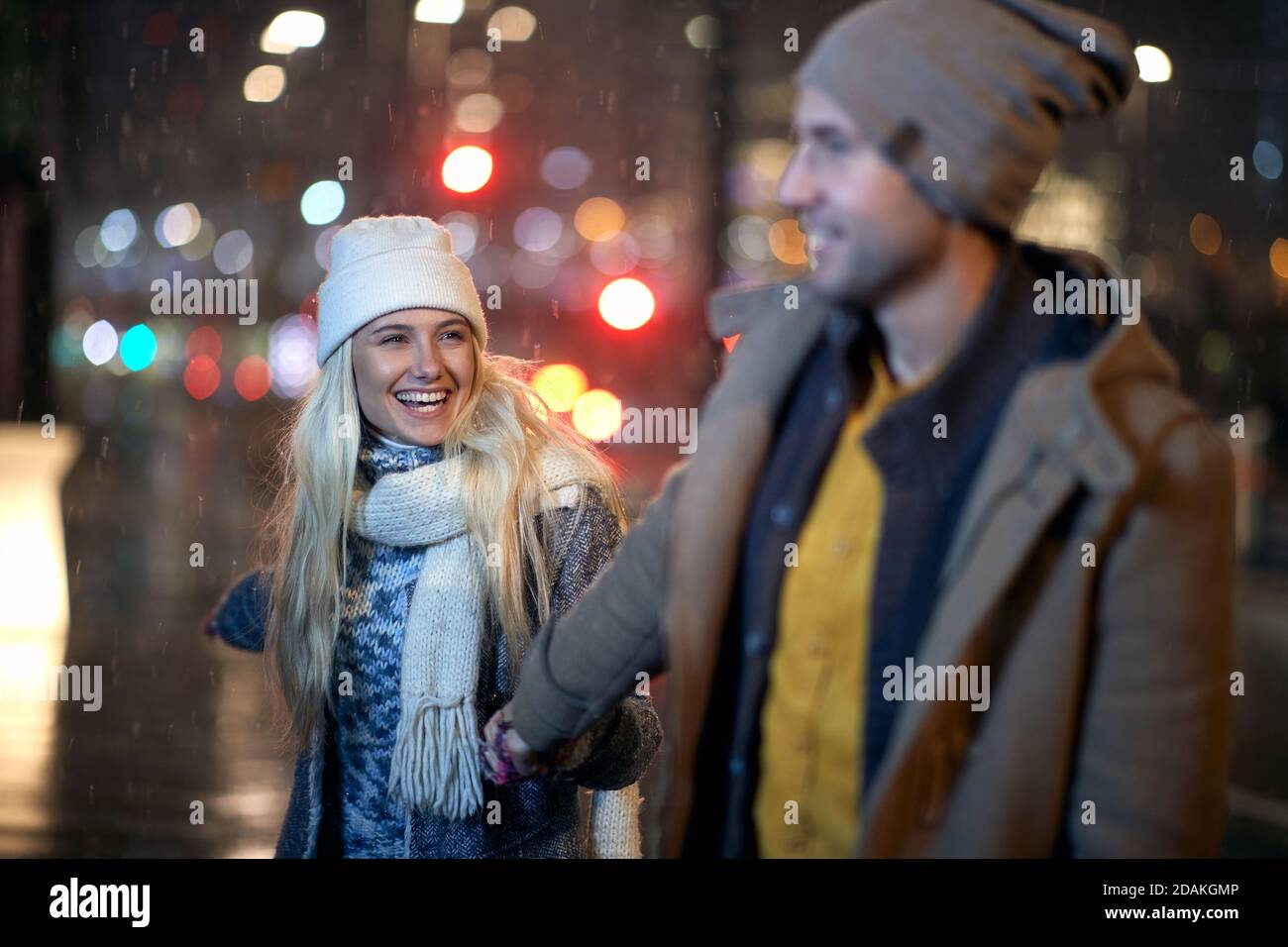 A young couple having good time together in a magical night on a snowy weather in the city. Love, together, walk, snow, city Stock Photo