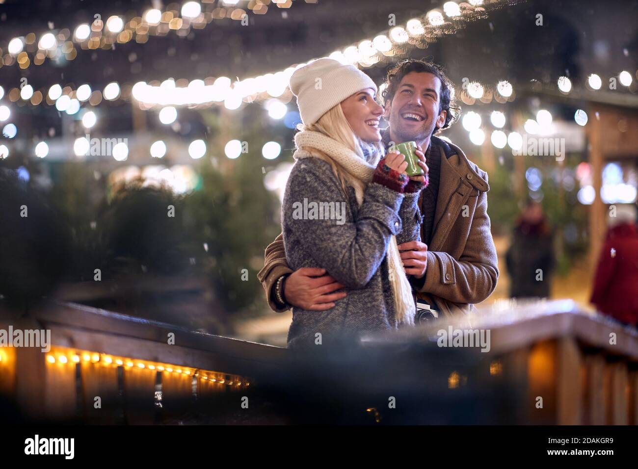 young caucasian couple in love enjoying the first snow, smiling. christmastime concept Stock Photo