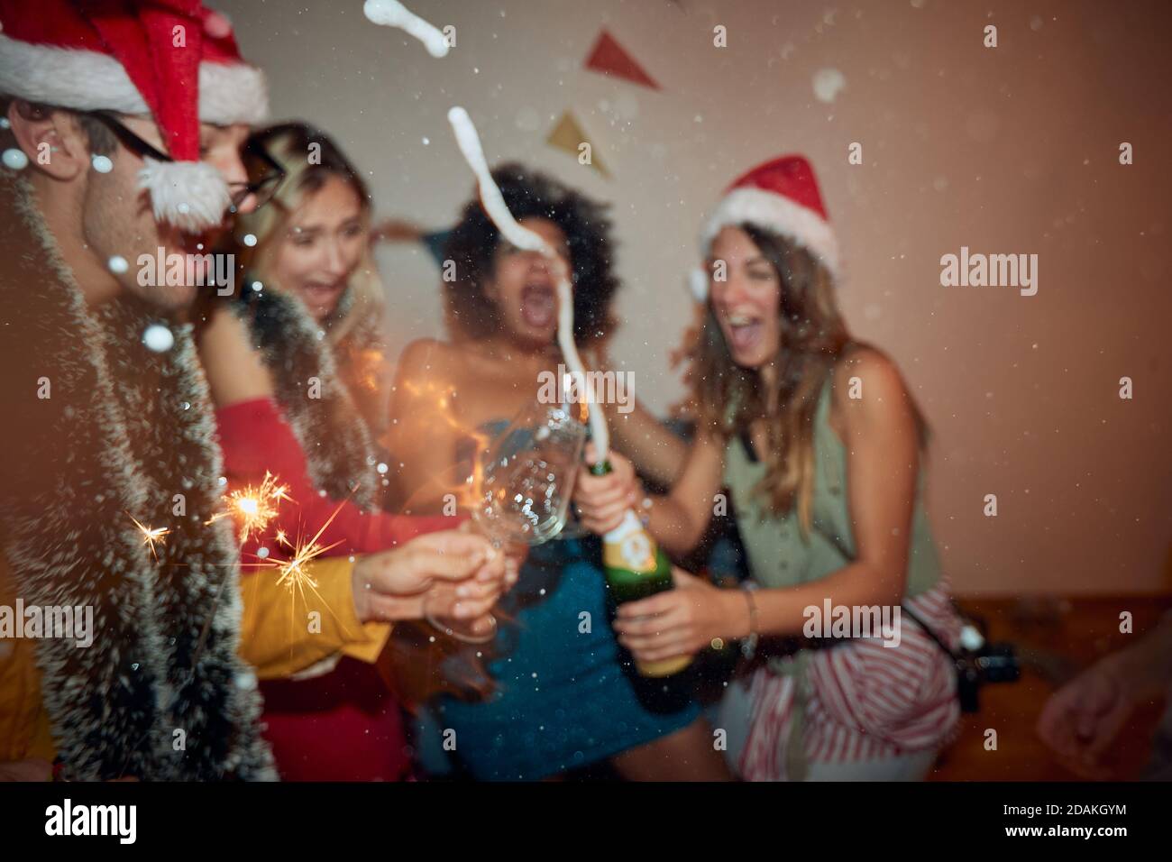Blurred group of cheerful friends in midnight euforia at a dynamic New Year eve home party. Friendship, together, party, New Year Stock Photo