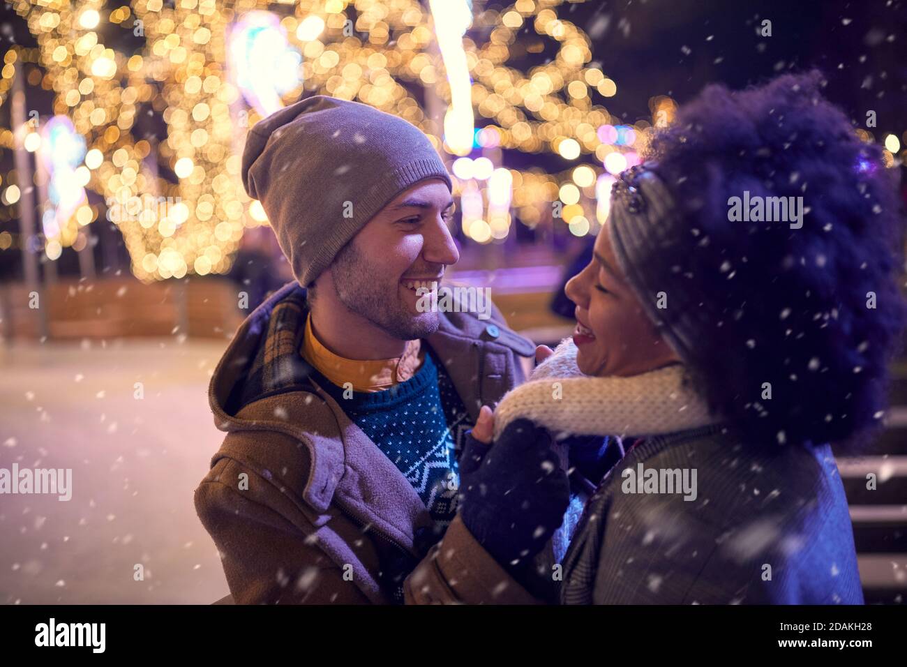 A young couple in romantic moments at ice rink on a beautiful night. Skating, closeness, love, together Stock Photo