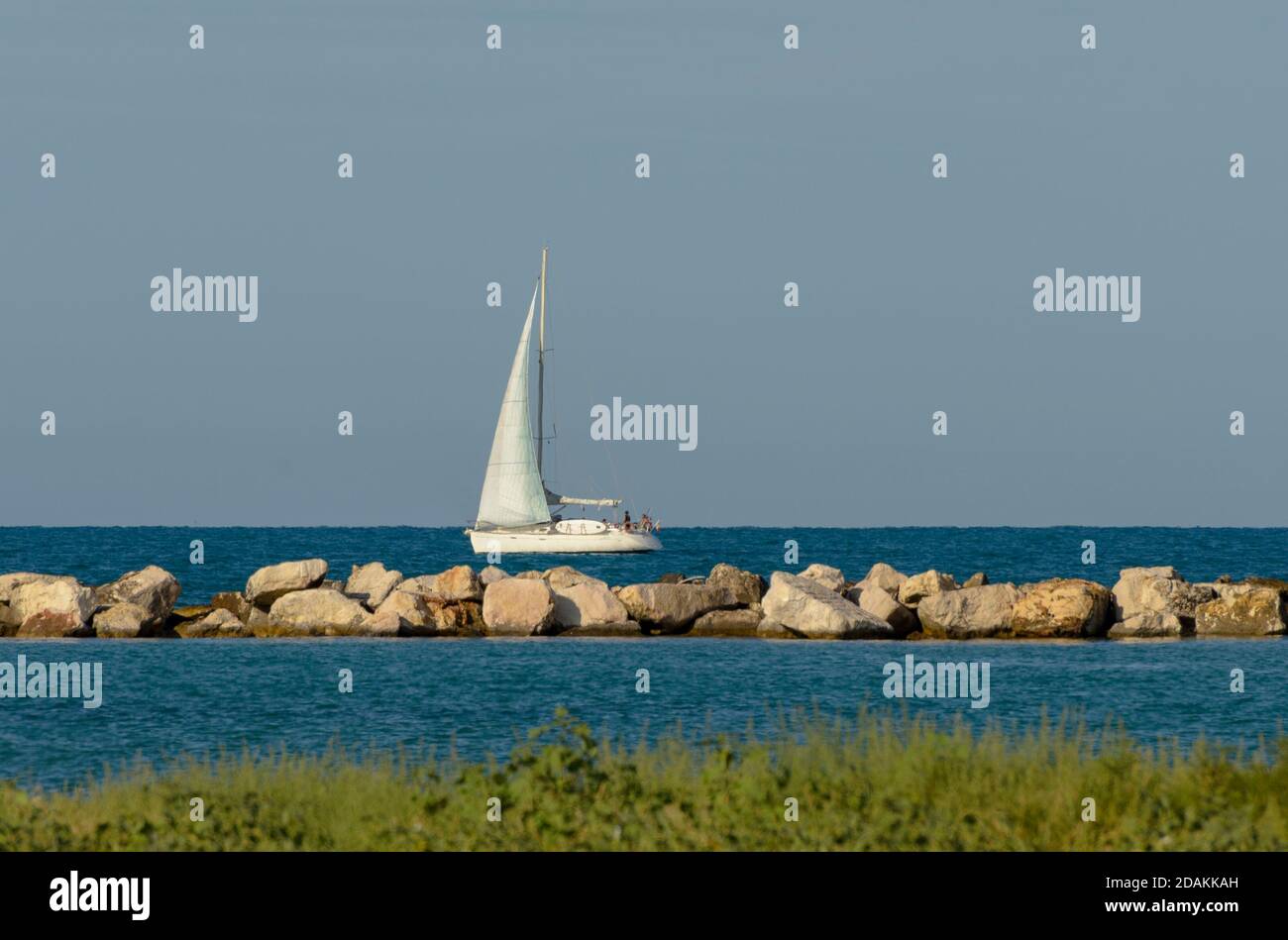 Sailboat in the middle of the sea near the coast Stock Photo