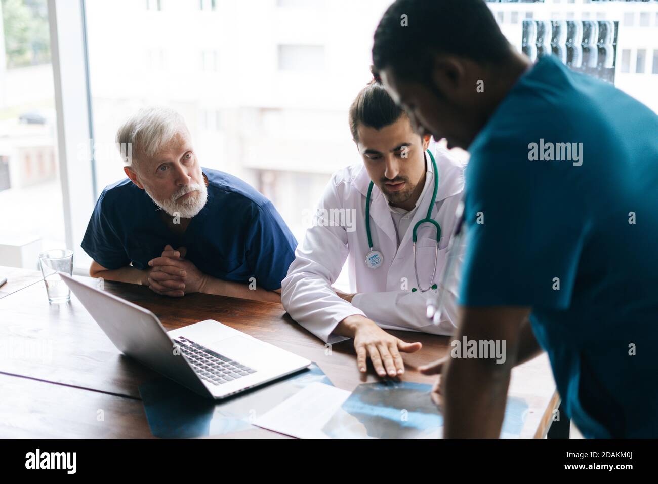 Team of multiethnic medical specialists discussing at chest Xray image during medical