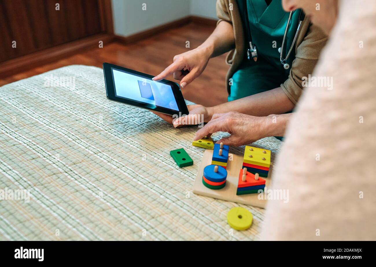 Female doctor showing geometric shapes to elderly patient Stock Photo