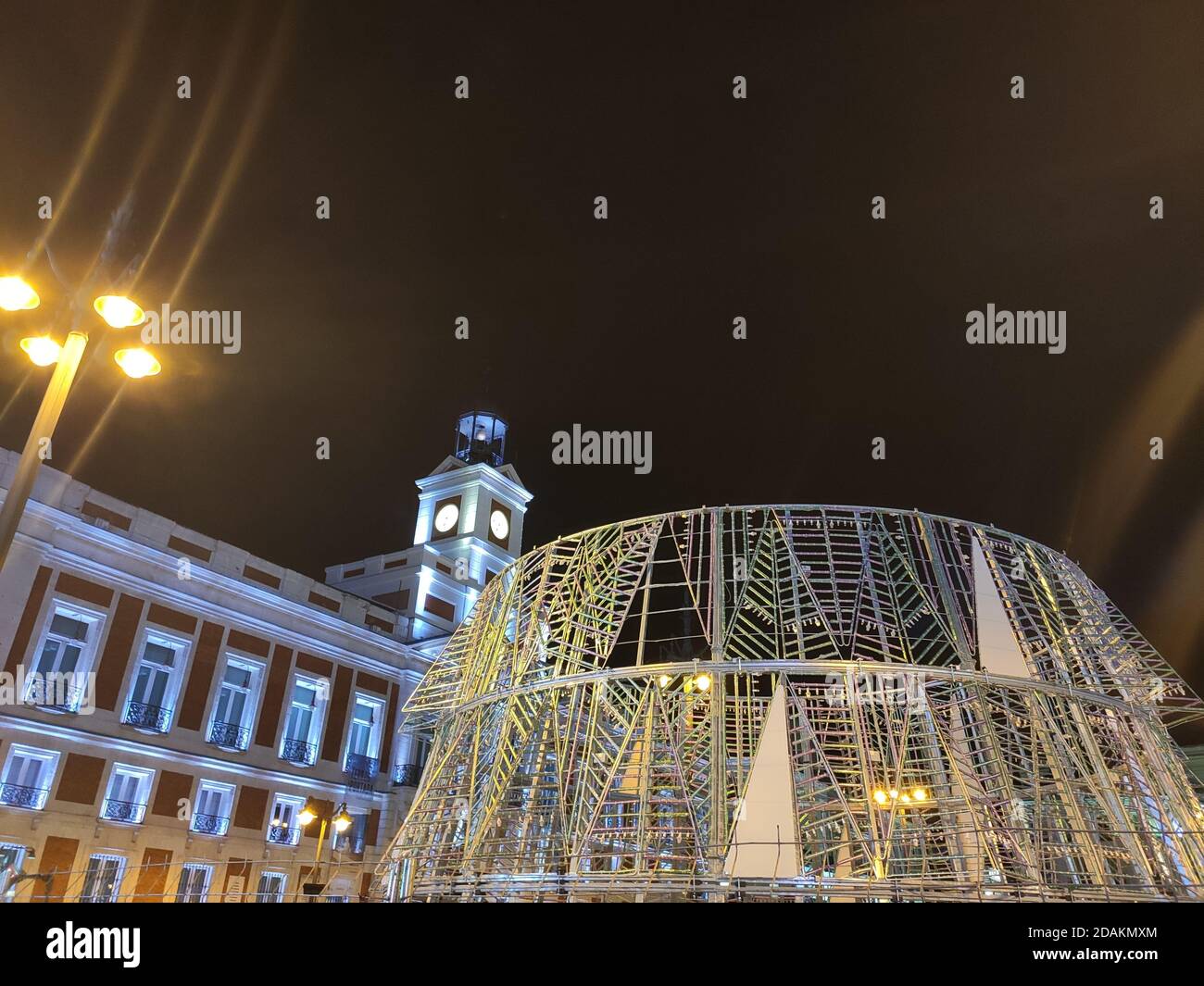 Installation and assembly of the characteristic Christmas tree and its lights in Puerta del Sol with the emblematic clock, in Madrid, Spain. Stock Photo
