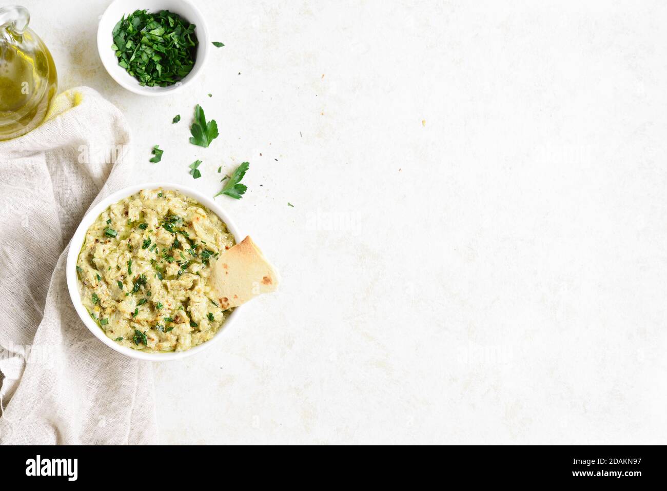 Baba ganoush (roasted eggplant dip) in bowl over light stone background with free text space. Vegetarian vegan food concept. Top view, flat lay Stock Photo
