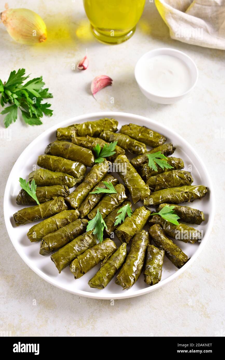 Dolma, stuffed grape leaves with rice and meat on light stone table