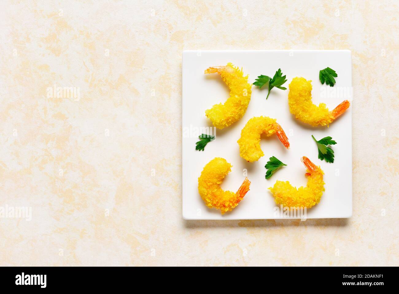Deep fried breaded prawn on white plate over light stone background ...