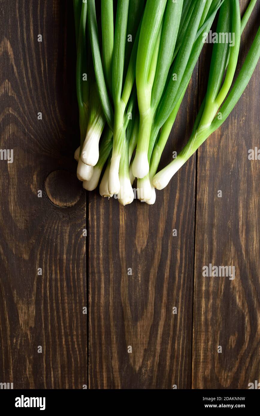 Fresh green onion on wooden background with free text space. Top view, flat lay Stock Photo