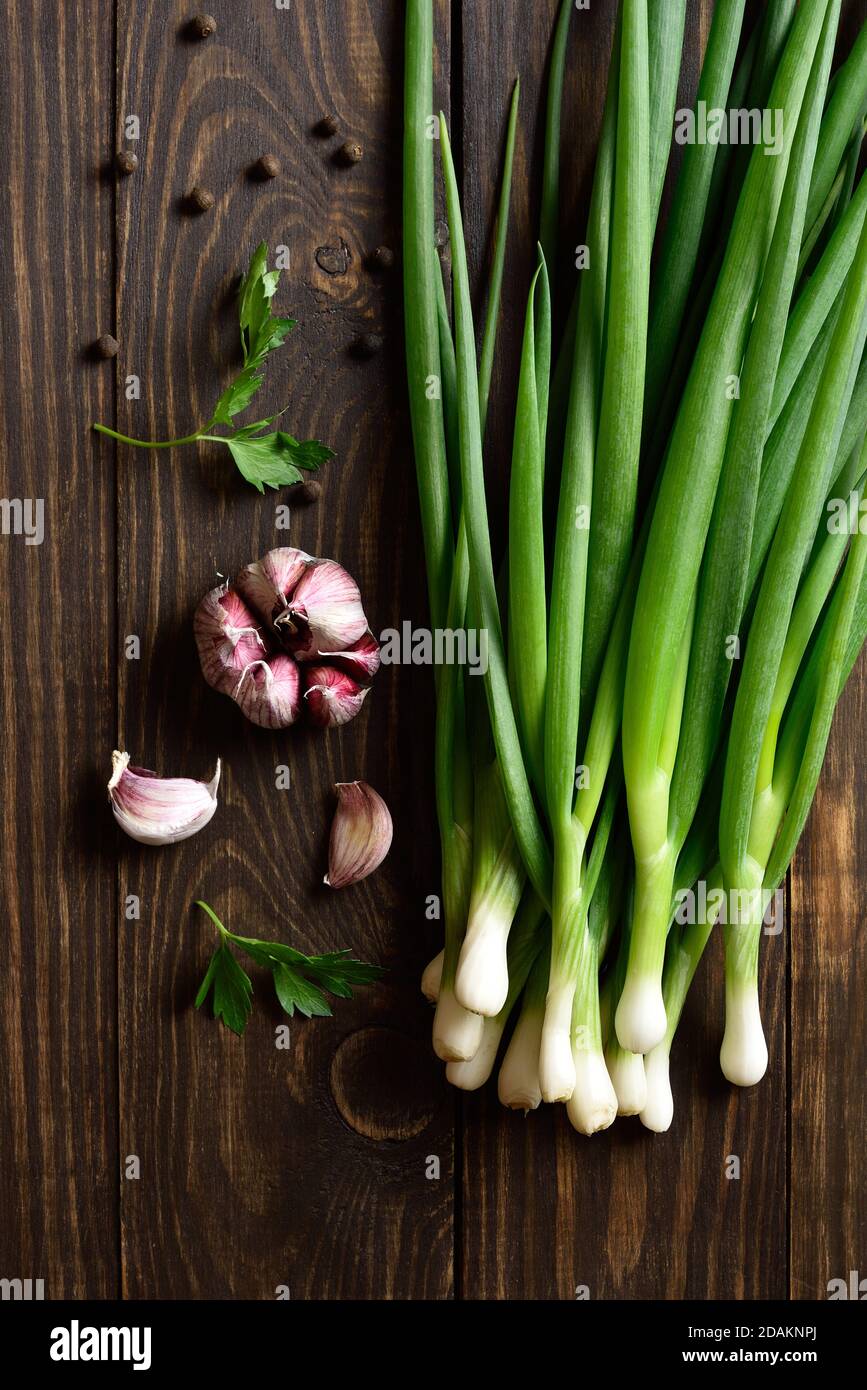 Fresh green onion and garlic on wooden background. Top view, flat lay Stock Photo