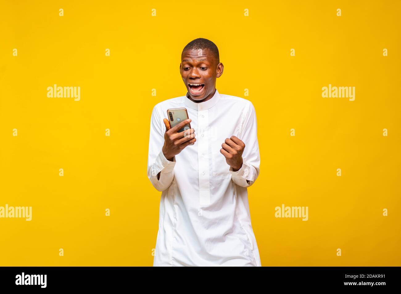 Excited African Muslim Man Feeling Happy While Looking At His Phone Stock Photo Alamy