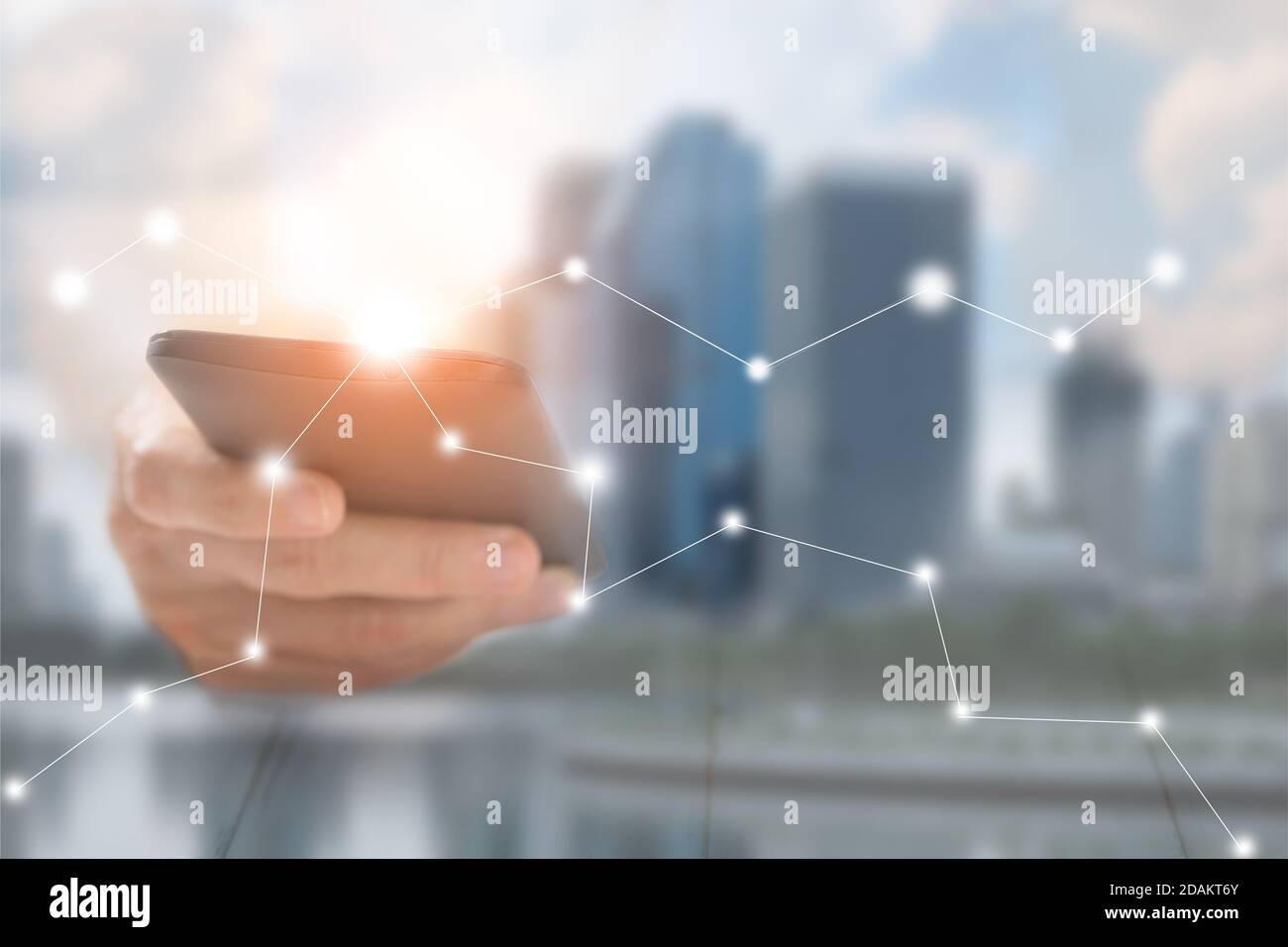 Hand of a businessman holding a smartphone. There is a network of business contacts. A concept of communication, this image focuses on blurring to be Stock Photo